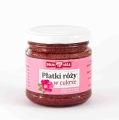 Szklany słoik z ciemnoczerwonymi „Płatkami róży w cukrze” i białą zakrętką o pojemności 220g. Etykieta w kolorze różowym z ilustracją kwiatu róży.